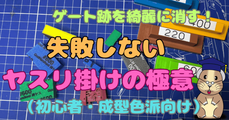 「ゲート跡を綺麗に消す！失敗しないヤスリ掛けの極意（初心者・成型色派向け）のアイキャッチ画像です。背景画像は青いカッティングボードの上に色々なヤスリが散乱しています。作業中の様子です。右下には私のキャラクターのナキウサギが学者帽をかぶって微笑んでいます。